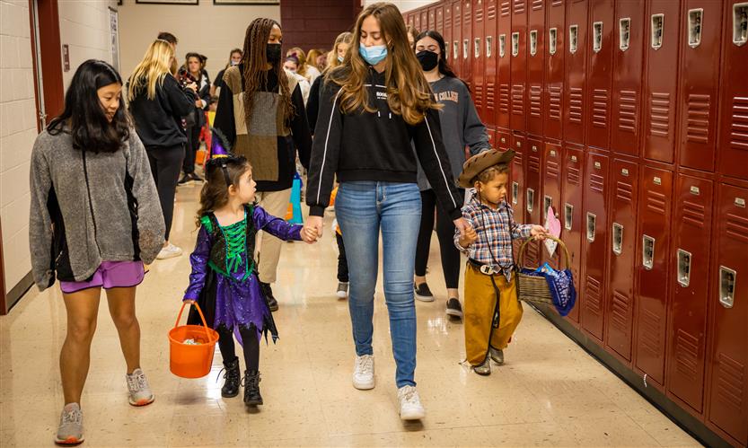 Children in costume trick or treat around school